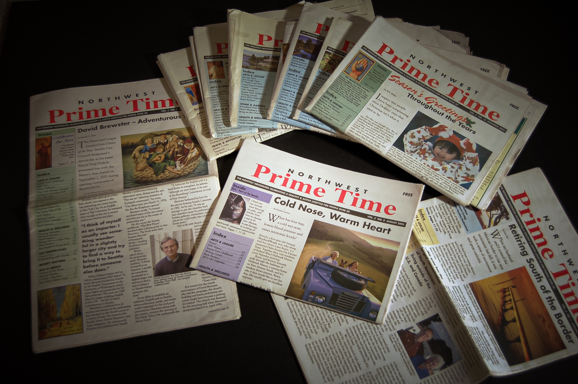 A collection of Northwest Prime Time newspapers arranged across a dark surface.