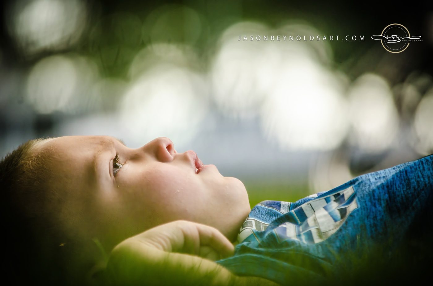 Boy Lying in Grass, Looking Up