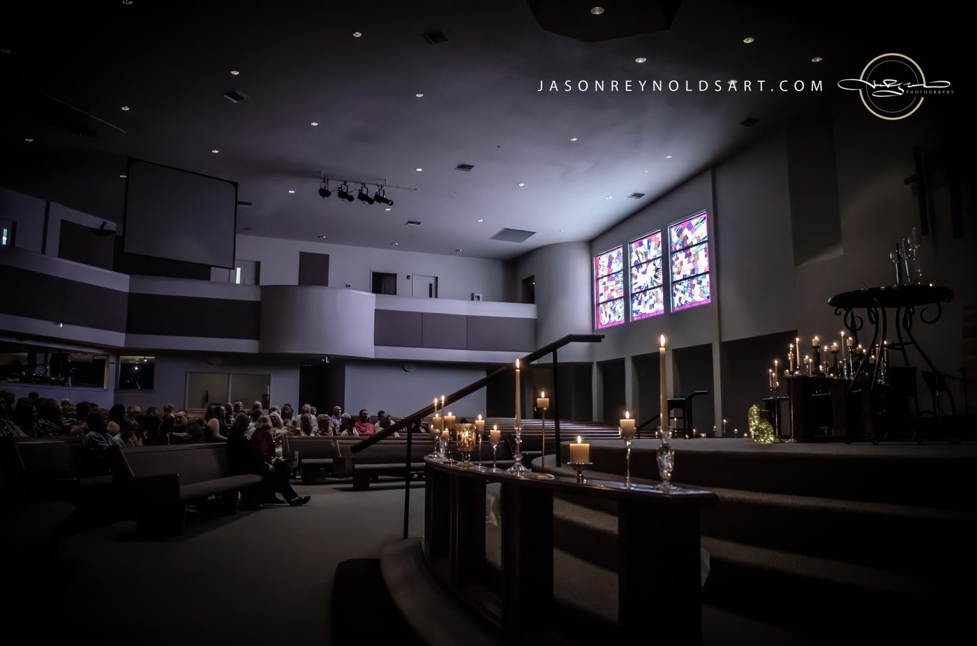 Candlelit Church Sanctuary with Stained-Glass Windows