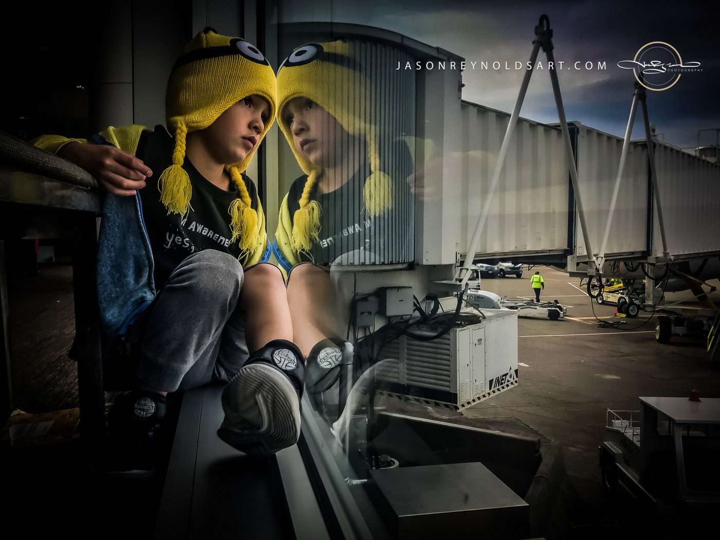 Child in Yellow Goggle-Style Hat Reflected in Terminal Window