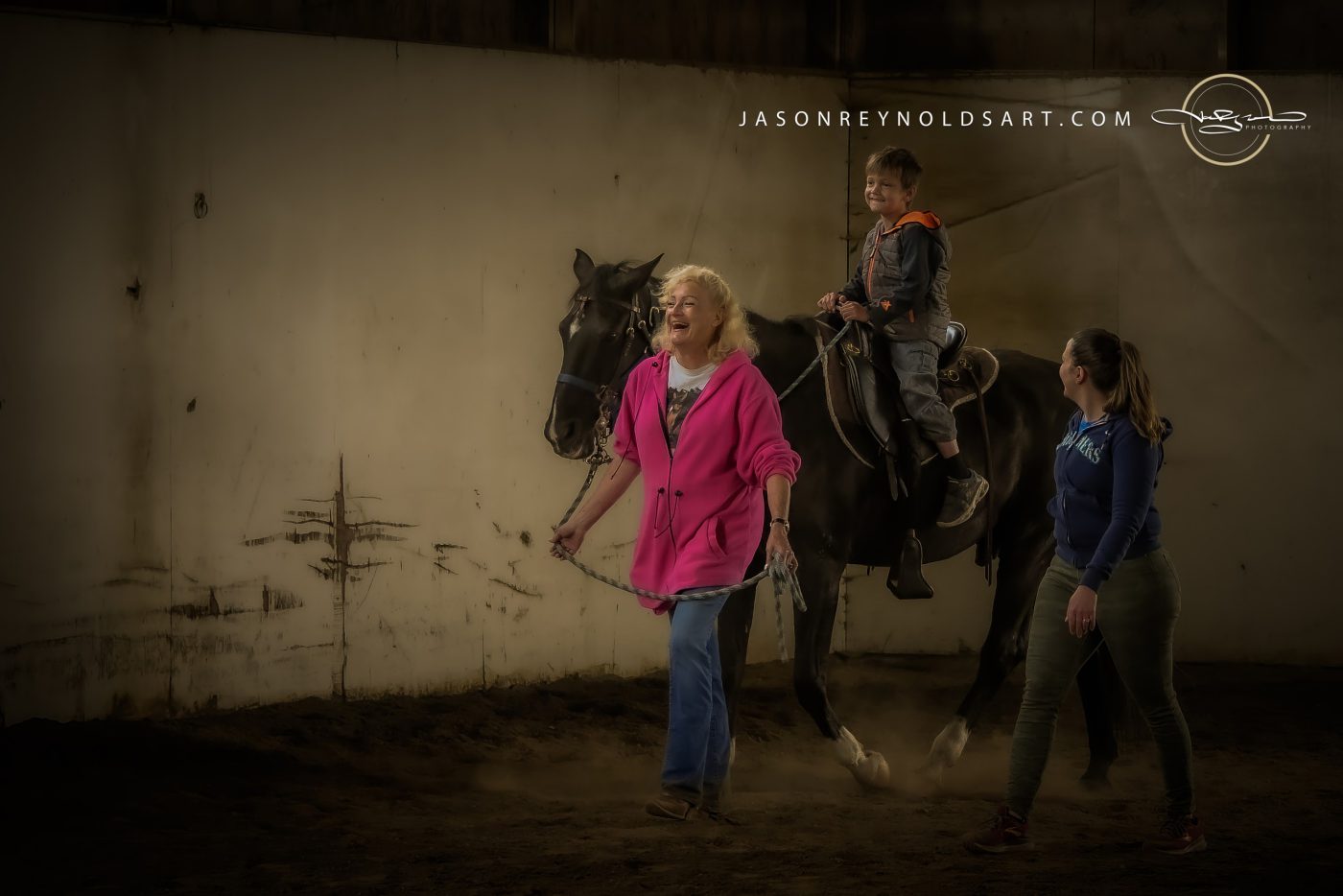 Child Riding Black Horse in Indoor Arena