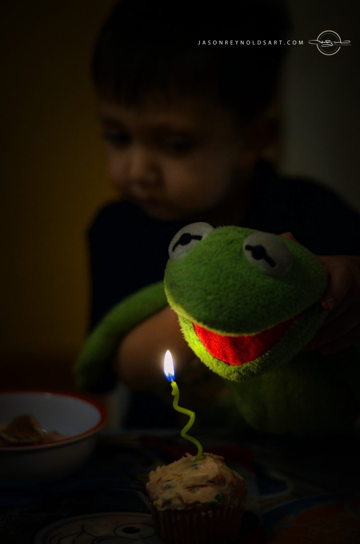 Child with Green Frog Puppet and Cupcake Candle