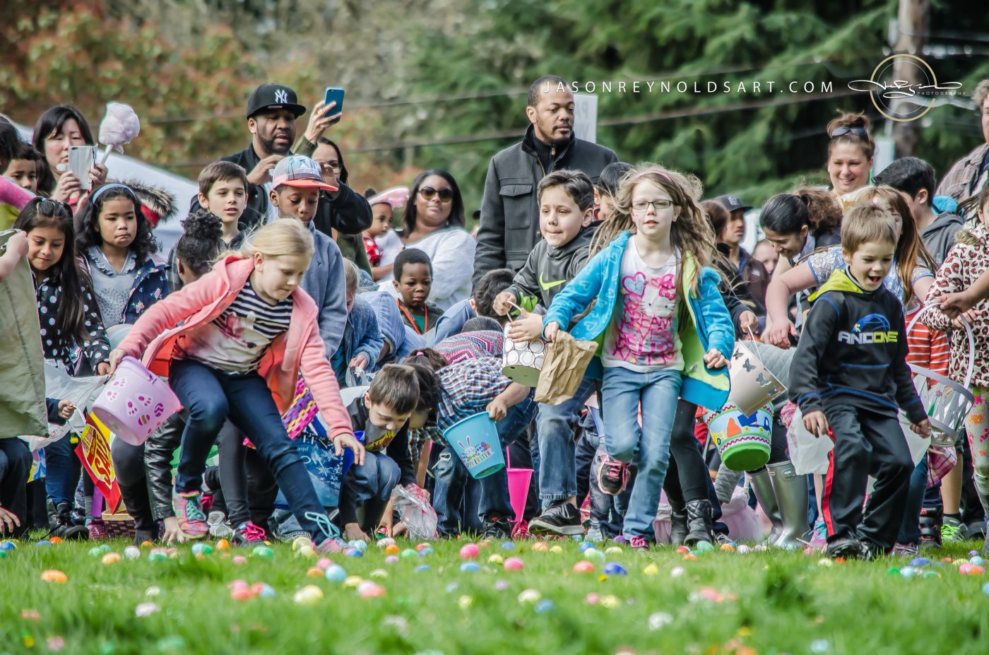 Children racing to collect colorful eggs on a grassy lawn
