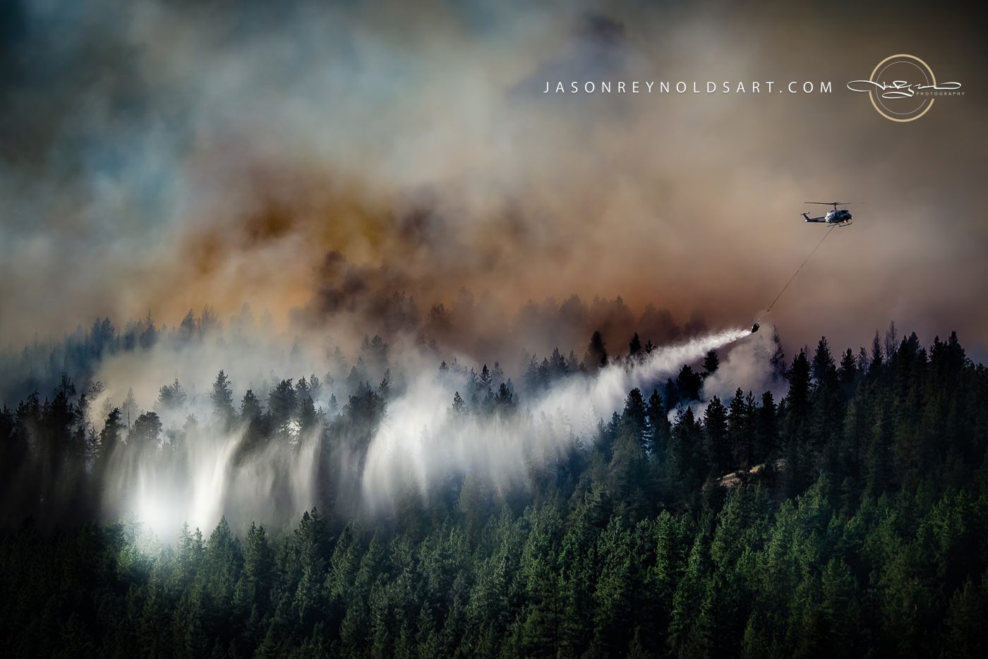 Firefighting Helicopter Drops Water Over Smoky Conifer Forest