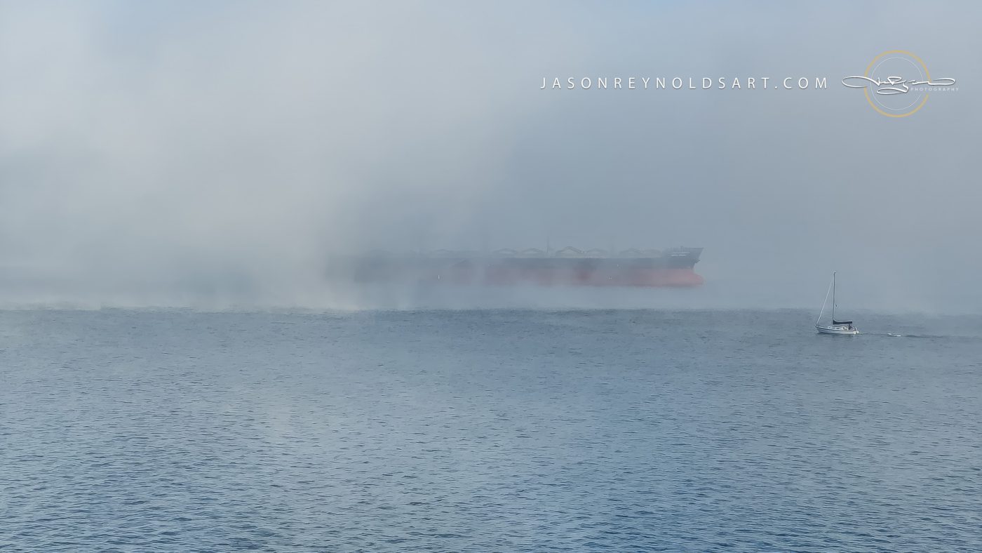 Freighter Emerging from Sea Fog with Sailboat