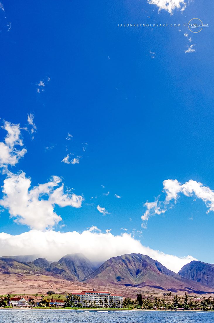 Lahaina shoreline and West Maui mountains under a deep blue sky