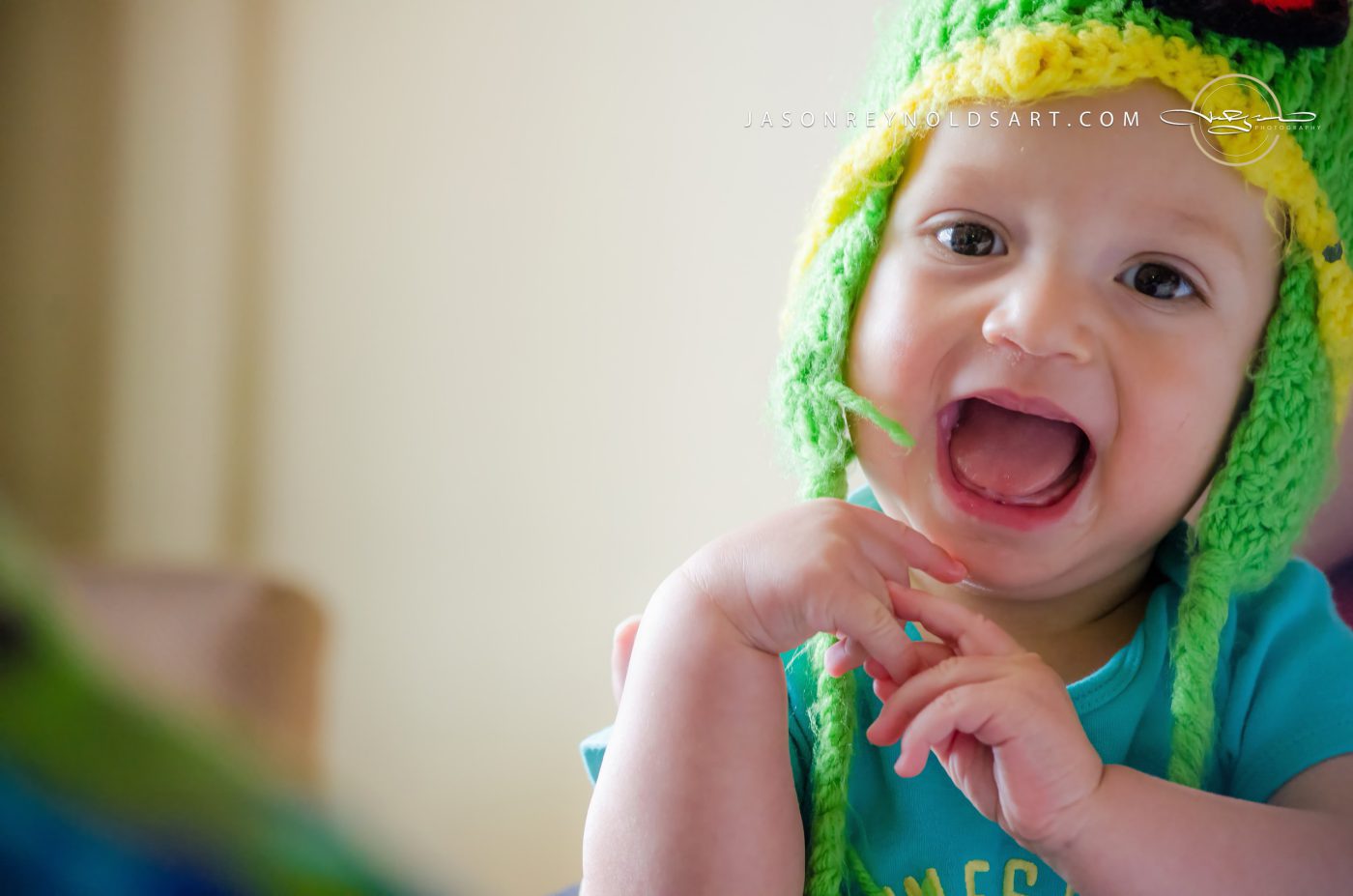 Laughing baby in green knit hat