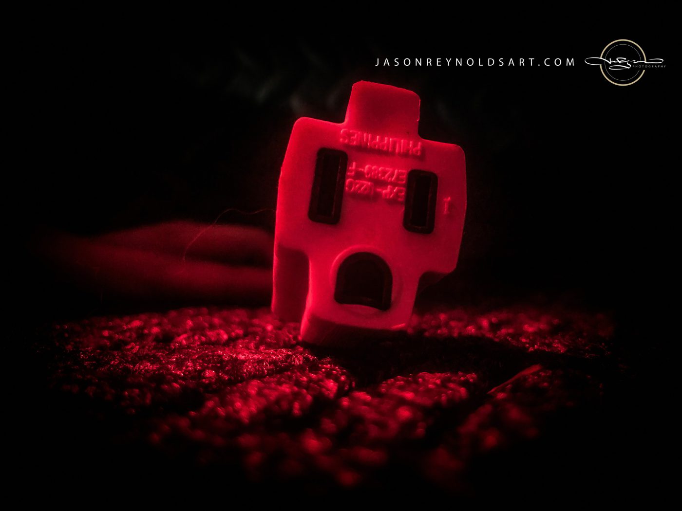 Red-Lit Two-Prong Plug Adapter on Textured Carpet