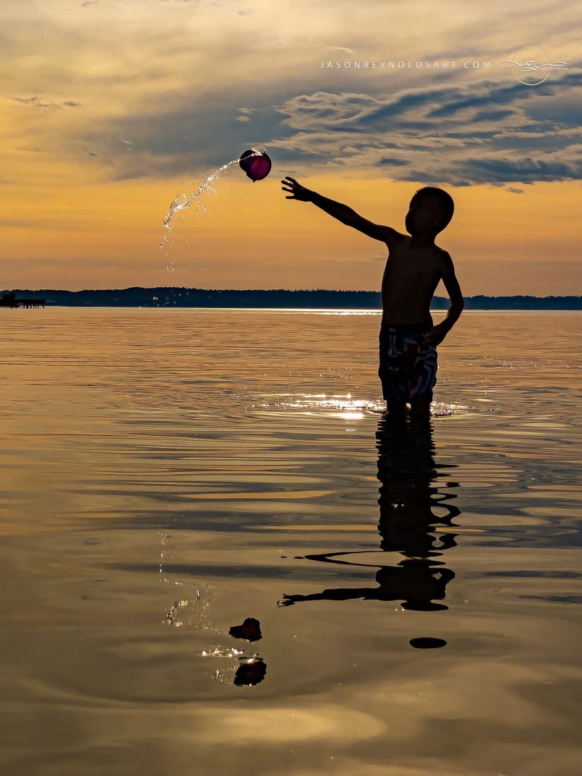 Silhouette of Boy Tossing Water Balloon at Sunset