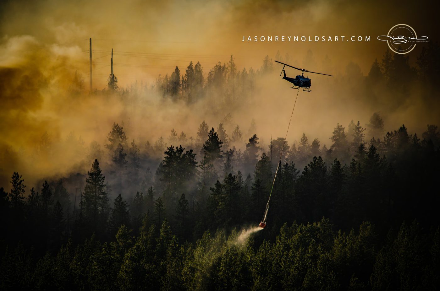 Spokane Valley helicopter fighting wildfire over pine forest