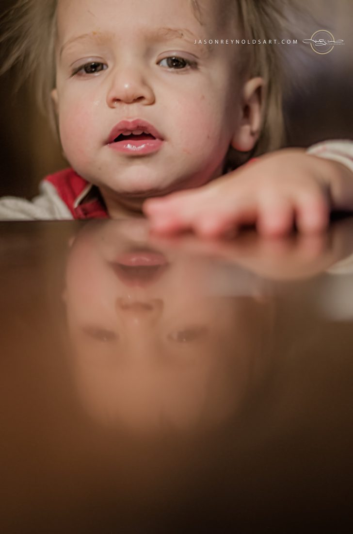 Toddler Reaching Over Reflective Table