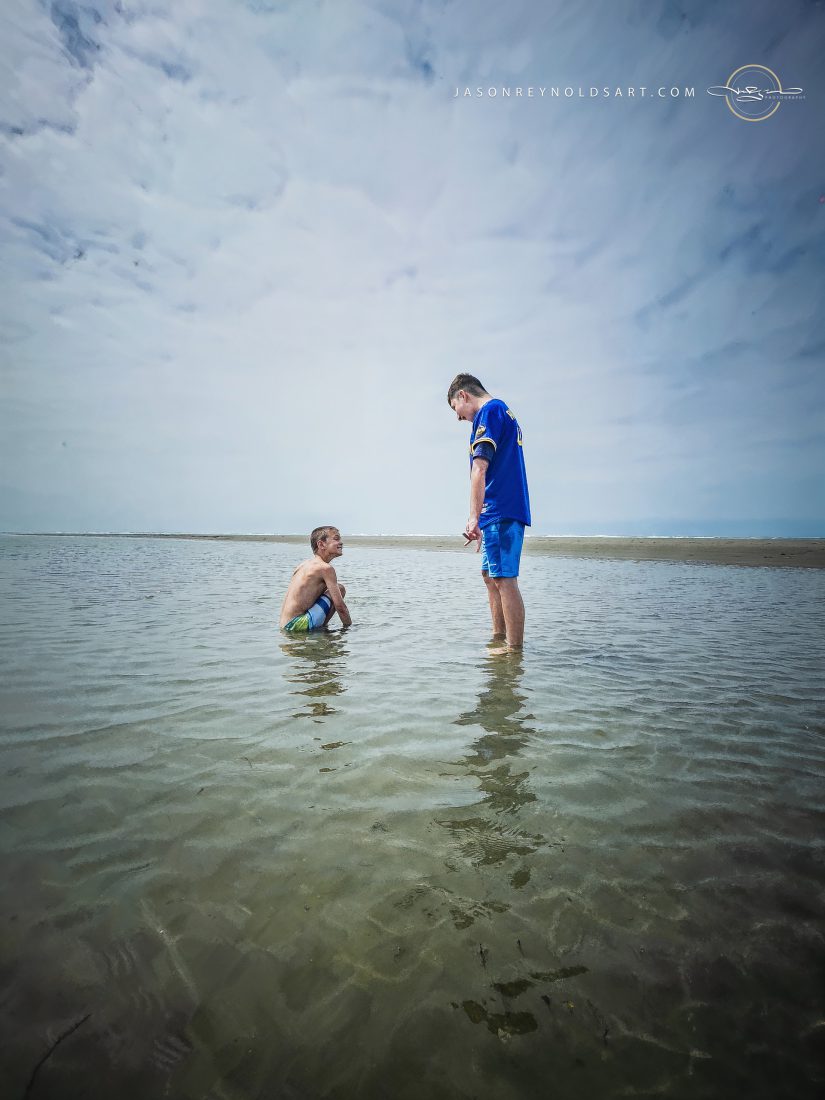 Two people in shallow tidal flats