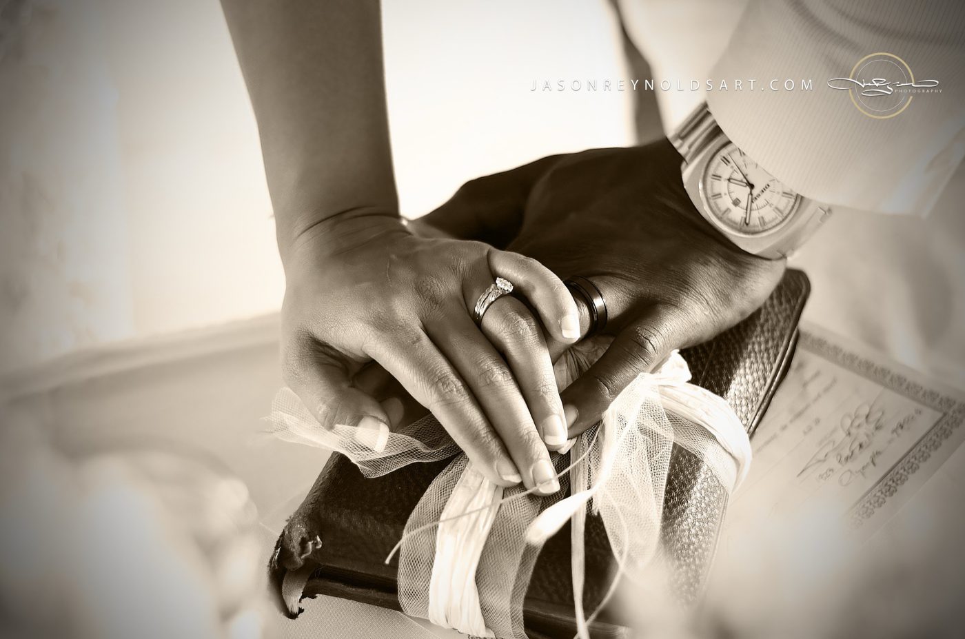 Wedding Rings and Hands over a Tied Book